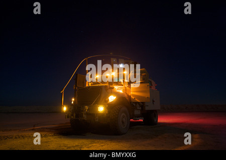 Ein MaxxPro mir beständig Hinterhalt geschützt (MRAP) Fahrzeug mit Lauflicht auf in der Nacht. Stockfoto