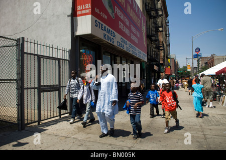 Fußgänger passieren das Meer und Salz Fischmarkt im Stadtteil Harlem in New York Stockfoto