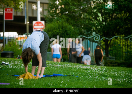 Yoga-Praktizierende Teilnahme eine kostenlose Yogastunde im Lenape Park in New York gegeben Stockfoto