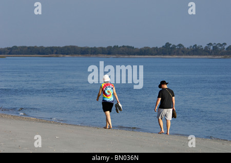 Paare, die am Wasserrand auf Folly Beach in Charleston County, South Carolina Stockfoto