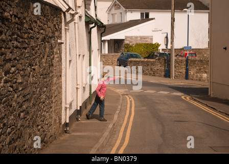 Ein kleiner Junge spielt Conkers in die leere Straße von Abergavenny (Wales) Stockfoto