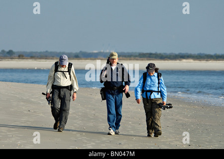 Drei Fotografen zu Fuß auf Folly Beach in Charleston County, South Carolina Stockfoto