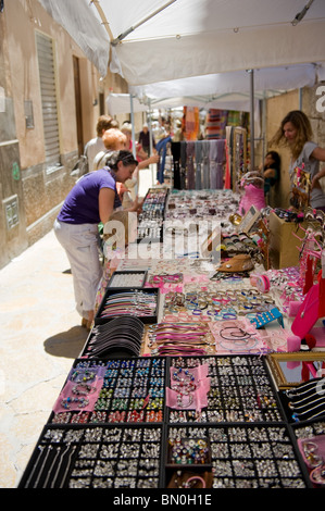 Touristen gehen und Einkaufen in einer schmalen Seitenstraße am Sonntagsmarkt in der Altstadt von Pollença, Mallorca 2010 Stockfoto