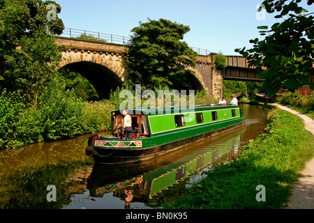 Großbritannien, England, Cheshire, Stockport, Marple, Narrowboat auf Peak Forest Canal Viadukt, neben Eisenbahnbrücke Stockfoto