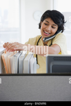 Hispanische Krankenschwester am Telefon sprechen Stockfoto