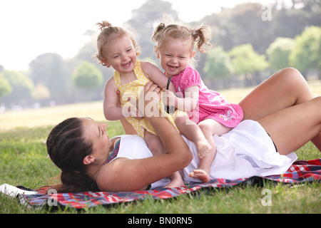 Mutter mit Töchtern im Park im Sommer spielen Stockfoto