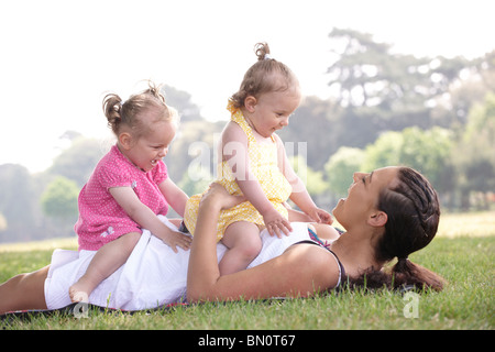 Mutter mit Töchtern im Park im Sommer spielen Stockfoto