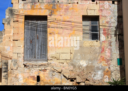 Eine alte Shop Buiding des gelben Stein mit verblassten und verwitterte Eichentür auf der einen Seite Zugriff durch Schritte Dingli, Malta Stockfoto