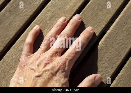 Hand des Mannes über sonnige Teak tropischen Holz Linien horizontal Bild Stockfoto