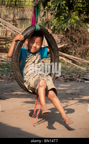 Kleiner Junge spielte in Reifenschaukel im Baan Tong Luang, Dorf der Hmong Leute im ländlichen Provinz Chiang Mai, Thailand. Stockfoto