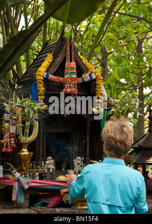 Hotelgast Platzierung Weihrauch auf buddhistischen Schrein im Four Seasons Resort, Chiang Mai, Thailand. Stockfoto