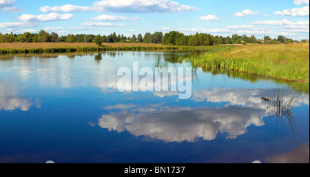 Sommer rushy Seeblick mit Wolken Reflexionen. Drei Schüsse zusammengesetztes Bild. Stockfoto