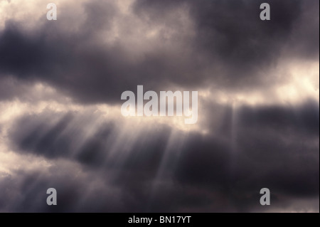 Sonnenstrahlen brechen durch dunkle Wolken Stockfoto