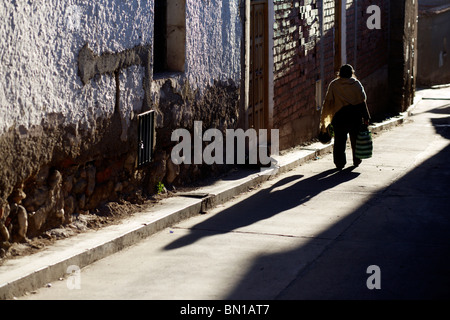 Eine Frau geht auf eine sonnige Straße in Potosí in Bolivien Stockfoto