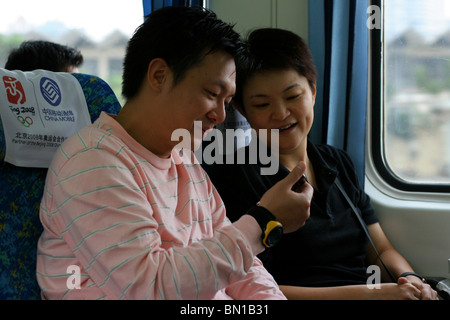 China, Hong Kong, Passagiere an Bord des Zuges vom Flughafen in die Stadt. Stockfoto