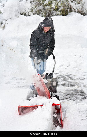 Teenager nutzt Schneefräsen nach Schneesturm. Stockfoto