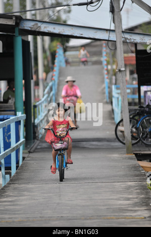 Die Lebensweise der Bewohner auf Pulau Ketam oder Carey Insel vor Kuala Selangor, Malaysia. Ein kleines Mädchen vorbei mit ihrer Mutter Radfahren Stockfoto