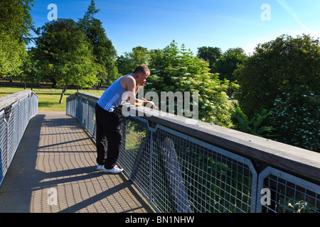 Ein Angler auf einer Brücke über den Fluss Great Ouse raucht eine Zigarette, Bedford, Bedfordshire, UK Stockfoto