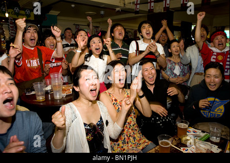 Südkoreanischen Fußball-Fans feiern ihr Team erzielte gegen Uruguay in einem Londoner Pub während der WM 2010 Stockfoto