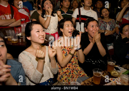 Aufgeregt, weibliche südkoreanische Fußballfans beobachten ihre Mannschaft spielen Uruguay in einem Londoner Pub während der WM 2010 Stockfoto