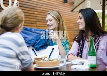 Freunde haben zusammen im Café im Freien, eine Frau, die neuen Kleidung Shopping Bag lunch Stockfoto