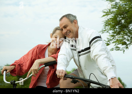 Älteres Paar Fahrrad fahren, lehnte sich gegen einander Stockfoto