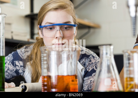 Junge Frau, die Durchführung von Experiment in Chemie-Labor Stockfoto