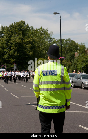 Metropolitan Police Officer in Hi-viz Jacke zurück zur Kamera. Stockfoto