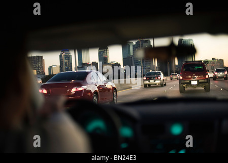 Fahren im Verkehr auf der Autobahn, im Hintergrund die Skyline der Stadt Stockfoto