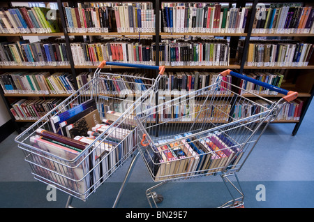 Bücher in einem Warenkorb in einer Bibliothek Stockfoto
