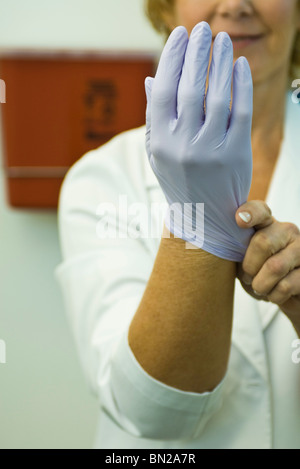 Einweg Latex-Handschuh anziehen Stockfoto