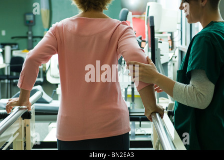 Patienten, die Rehabilitanden wenige Übungen mit Hilfe von Physiotherapeuten Stockfoto