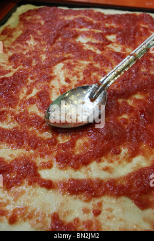 Stadien der Vorbereitung der Pizza Tomatensauce auf dem Pizzateig verteilen Stockfoto