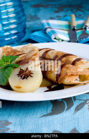 Gerollte Pfannkuchen mit pochierte Birne Stockfoto