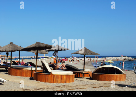 Urlauber am Strand, Puerto Banus, Marbella, Costa Del Sol, Provinz Malaga, Andalusien, Spanien, Europa. Stockfoto