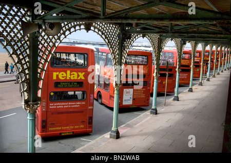 Eine Reihe von Brighton & Hove Bus und Coach Unternehmen Doppeldecker Busse stehen unter den verzierten Bögen in Madeira Drive in Brighton Stockfoto