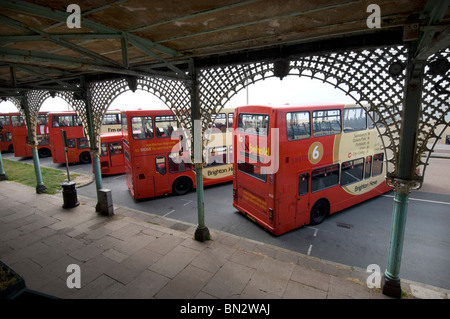 Eine Reihe von Brighton & Hove Bus und Coach Unternehmen Doppeldecker Busse stehen unter den verzierten Bögen in Madeira Drive in Brighton Stockfoto