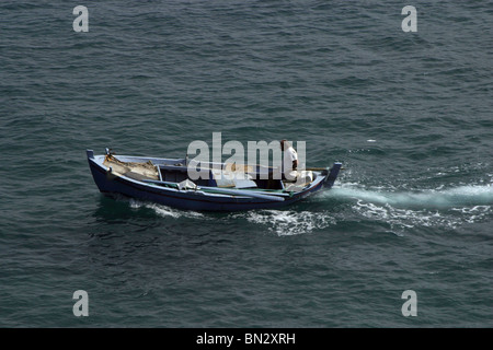 Mann in einem kleinen Fischerboot auf der griechischen Insel Korfu. Stockfoto