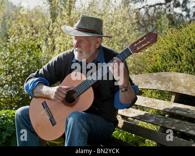 ÄLTERER MANN SPIELT KLASSISCHEN GITARRE IM FREIEN Stockfoto