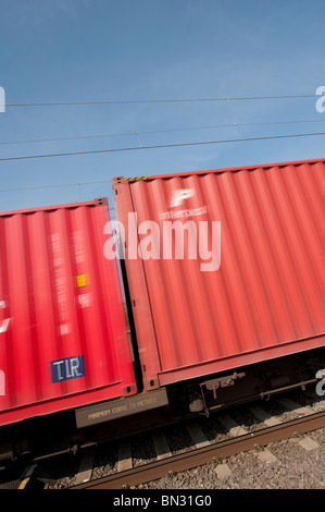 Fracht-Container am Zug entlang der englischen Eisenbahn vorbei zu beschleunigen. Stockfoto