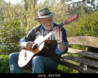 ÄLTERER MANN SPIELT KLASSISCHEN GITARRE IM FREIEN Stockfoto