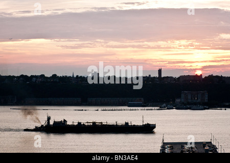 Blick auf den Fluss von West Side Manhattan von tug drängen Lastkahn Hudson River, Sonnenuntergang über New Jersey Palisades Stockfoto