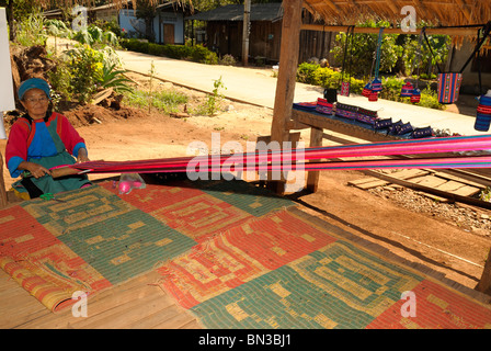 Porträt einer Lisu-Frau mit einem Webstuhl Weben und Tracht in Dao Stadt, Bergstämme, in der Nähe von Chiang Mai, Thailand Stockfoto