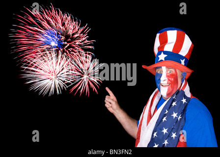 Ein patriotischer Mann gekleidet in roten, weißen und blauen Punkten, Feuerwerkskörper in den Himmel. Stockfoto