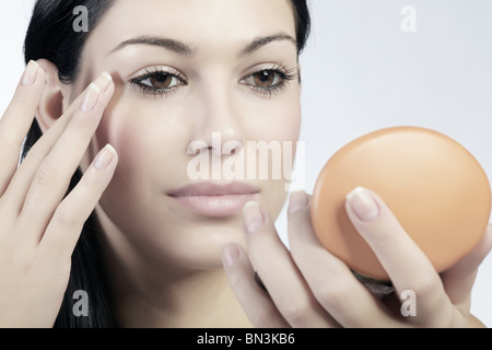 Junge Frau Lidschatten auftragen Stockfoto