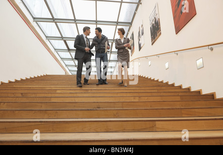 Drei Geschäftsleute gehen nach unten Stockfoto