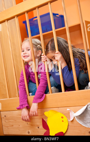 Junge Mädchen sitzt hinter einem Geländer Stockfoto