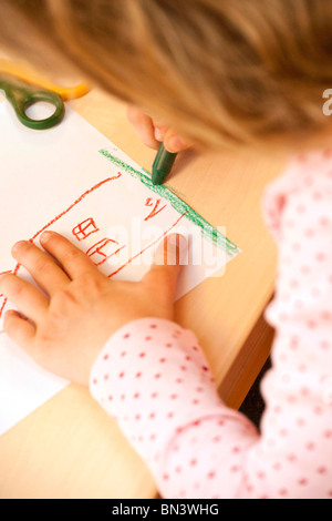 Junges Mädchen Zeichnen eines Bildes mit einem Wachs Buntstift, Nahaufnahme Stockfoto
