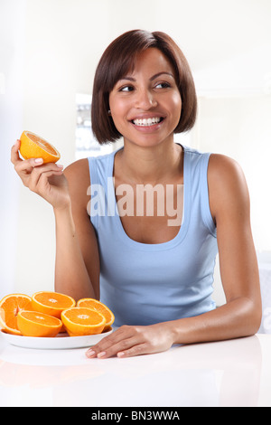 FRAU ESSEN ORANGEN Stockfoto