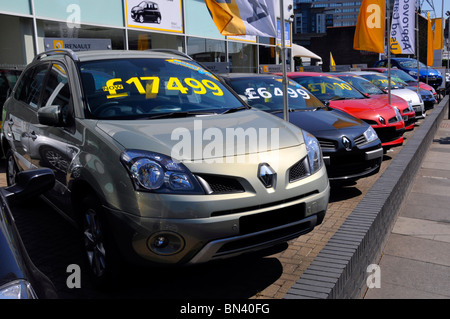 Eine Reihe gebrauchter Fahrzeuge vor dem Renault Autohändler auf einem Vorplatz, auf dem die Preise für jedes Fahrzeug im Ilford East London England UK angezeigt werden Stockfoto